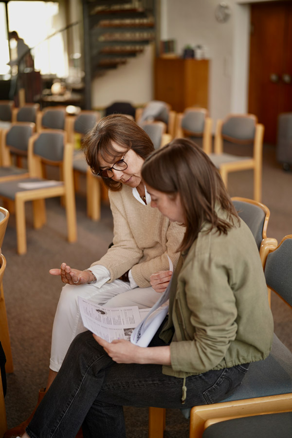 Zwei Frauen schauen gemeinsam in eine Liturgie